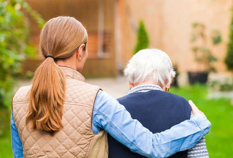 Caregiver with arm around senior